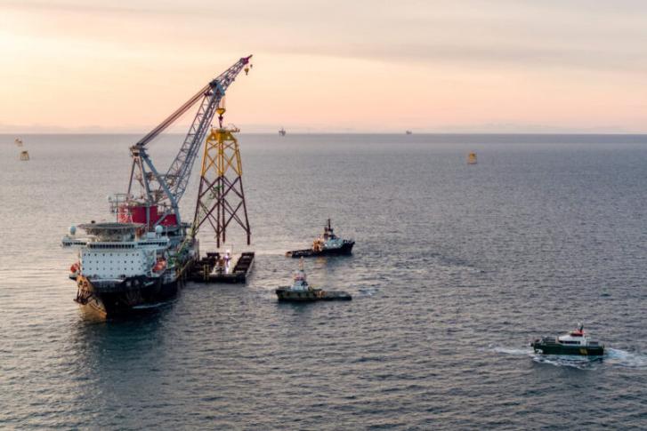 Offshore crane vessel lifting a steel jacket vertically from a transport barge