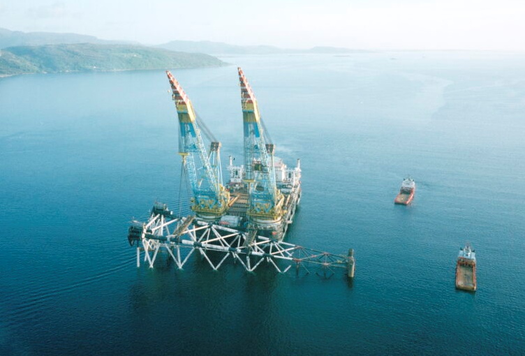 Offshore crane vessel supporting a horizontally lifted steel jacket in the water